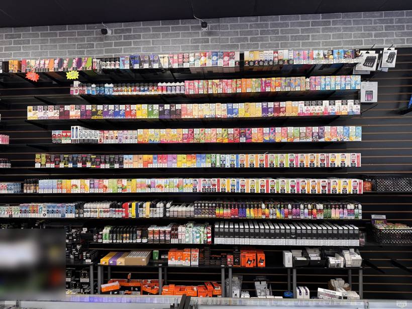 Wall of e-liquids and disposable vapes